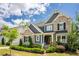 Beautiful two-story home featuring a stone and blue exterior with manicured landscaping at 2737 Willow Rock Ln, Apex, NC 27523