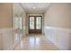 Spacious foyer featuring hardwood floors, wainscotting, and a stylish glass paneled front door at 2737 Willow Rock Ln, Apex, NC 27523