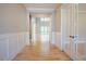 Light-filled hallway featuring hardwood floors, wainscotting and glass paneled doors at 2737 Willow Rock Ln, Apex, NC 27523