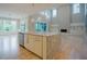 Open-concept kitchen with white cabinets, stone countertops, hardwood floors, and view of the living area at 2737 Willow Rock Ln, Apex, NC 27523