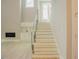 Modern staircase with glass railing, built-in storage, and lots of natural light at 2737 Willow Rock Ln, Apex, NC 27523