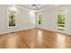 Bright bedroom features tray ceilings, a ceiling fan, hardwood floors, and multiple windows for natural light at 2819 Ellis Chapel Rd, Bahama, NC 27503