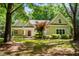 Charming home featuring a landscaped front yard, covered porch, and mature trees creating a peaceful setting at 2819 Ellis Chapel Rd, Bahama, NC 27503