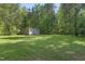 Exterior shot of a large metal outbuilding surrounded by an open lawn and many trees at 2819 Ellis Chapel Rd, Bahama, NC 27503