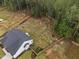 Aerial view showcasing a spacious backyard with trees, grass, and a modern home at 297 Sexton Ln, Wendell, NC 27591
