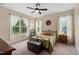 Cozy bedroom with natural light, neutral walls, decorative wreath and dark metal bed frame at 297 Sexton Ln, Wendell, NC 27591