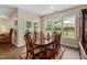 Bright dining room featuring a wood table, red rug, and multiple windows overlooking the backyard at 297 Sexton Ln, Wendell, NC 27591