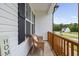 Cozy front porch features a wicker chair, wooden railings, and a view of the well-maintained street and neighboring homes at 297 Sexton Ln, Wendell, NC 27591