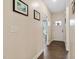 Bright hallway with hardwood floors, neutral paint, and decorative wall art, leading to various rooms within the home at 297 Sexton Ln, Wendell, NC 27591