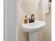 A white pedestal sink sits below a round mirror with two hand towels hanging beside it at 297 Sexton Ln, Wendell, NC 27591