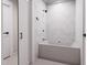 Elegant bathroom featuring a modern soaking tub with stylish marble-look tile surround and sleek black fixtures at 300 Westerman Pl, Smithfield, NC 27577