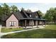 Charming home with a covered porch, featuring a combination of brick and dark siding at 300 Westerman Pl, Smithfield, NC 27577