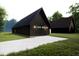 Modern detached garage with a stylish black exterior, double doors, and ample parking space on a concrete driveway at 300 Westerman Pl, Smithfield, NC 27577