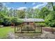 Backyard with an enclosed garden space, brick patio, lush trees, and privacy at 3125 Stanford Dr, Durham, NC 27707