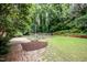 Backyard with an enclosed garden space, brick patio, lush trees, and privacy at 3125 Stanford Dr, Durham, NC 27707