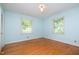 Bright bedroom features hardwood floors, neutral paint, and two large windows for natural light at 3125 Stanford Dr, Durham, NC 27707