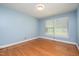 Bright blue bedroom with hardwood floors and a window allowing plenty of natural light at 3125 Stanford Dr, Durham, NC 27707