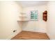Cozy bedroom with corner shelves and a window offering natural light, complemented by wood-look flooring at 3125 Stanford Dr, Durham, NC 27707
