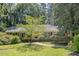 Traditional home exterior featuring a brick facade, well-manicured lawn, and mature trees providing shade at 3125 Stanford Dr, Durham, NC 27707