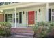 Charming home entrance featuring a bright red door with sidelights and classic black sconces at 3125 Stanford Dr, Durham, NC 27707