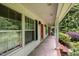 Covered front porch with shuttered windows, brick accents, and a vibrant red door, creating a welcoming entrance at 3125 Stanford Dr, Durham, NC 27707