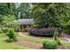 Inviting single story home with a well-manicured lawn, mature trees, and a winding brick path to the front entrance at 3125 Stanford Dr, Durham, NC 27707