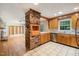 Eat-in kitchen featuring brick accent wall, wooden cabinetry, stainless steel appliances, and tile flooring at 3125 Stanford Dr, Durham, NC 27707