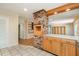 Kitchen showing brick accent wall, wooden cabinetry, and tile flooring, leading to adjacent living spaces at 3125 Stanford Dr, Durham, NC 27707