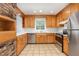 Updated kitchen features stainless steel appliances, tile floors, and light oak cabinets at 3125 Stanford Dr, Durham, NC 27707