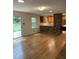 Open-concept living area with hardwood floors, kitchen view, and access to outdoor patio at 3125 Stanford Dr, Durham, NC 27707