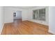 Open-concept living room with hardwood floors, large windows, and seamless transition to other spaces at 3125 Stanford Dr, Durham, NC 27707