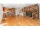 Open-concept living area boasts hardwood floors, an exposed brick fireplace, and views into the kitchen at 3125 Stanford Dr, Durham, NC 27707