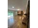 Open-concept living area with hardwood floors, kitchen view, and access to outdoor patio at 3125 Stanford Dr, Durham, NC 27707
