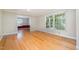Bright living room showcasing hardwood floors, large windows, and an open layout connecting to other living spaces at 3125 Stanford Dr, Durham, NC 27707