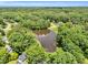 Overhead view of a tree-lined neighborhood and a calm pond reflecting the sky, offering natural beauty at 324 Waterside Dr, Sanford, NC 27330