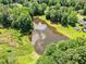 A captivating aerial shot capturing a serene pond reflecting the sky, framed by lush greenery and trees at 324 Waterside Dr, Sanford, NC 27330