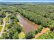 An aerial shot features homes surrounded by lush trees, highlighting the tranquil pond and blue sky at 324 Waterside Dr, Sanford, NC 27330