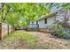 Large backyard with mature trees, wooden fence, and deck access at 324 Waterside Dr, Sanford, NC 27330