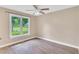 Neutral bedroom with updated flooring, a ceiling fan, and a large window overlooking the yard at 324 Waterside Dr, Sanford, NC 27330