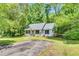 Attractive single-story home with a well-kept lawn, mature trees, and a paved driveway leading to the property at 324 Waterside Dr, Sanford, NC 27330