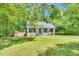 Charming single-story home with a well-maintained lawn, mature trees, and a cozy, inviting facade at 324 Waterside Dr, Sanford, NC 27330