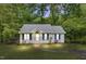 Charming single-story home featuring a well-manicured lawn, walkway, and inviting front porch, framed by lush trees at 324 Waterside Dr, Sanford, NC 27330
