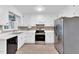 Eat-in kitchen with new stainless appliances, white cabinets, and new laminate flooring at 324 Waterside Dr, Sanford, NC 27330