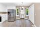 Eat-in kitchen with new stainless refrigerator, white cabinets, and new laminate flooring at 324 Waterside Dr, Sanford, NC 27330