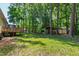 A large, wooded backyard features a deck and covered area providing a beautiful outdoor living space at 3359 Denise St, Durham, NC 27704