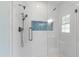 Modern shower featuring white tiling, and a unique blue accent tile pattern for a touch of elegance at 3359 Denise St, Durham, NC 27704