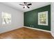 Well-lit bedroom with hardwood flooring, windows, and a modern ceiling fan at 3359 Denise St, Durham, NC 27704