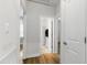 Hallway with hardwood floors leads to a bathroom and other rooms, all painted in neutral colors at 3359 Denise St, Durham, NC 27704