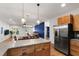 Open kitchen with stainless steel appliances and wood cabinets, seamlessly flowing into the dining and living areas at 3359 Denise St, Durham, NC 27704