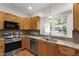Updated kitchen with stainless steel appliances, light wood cabinets, and a mosaic tile backsplash at 3359 Denise St, Durham, NC 27704
